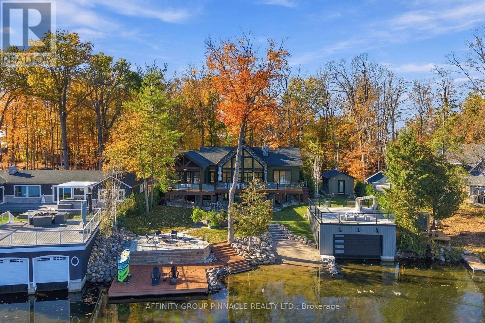 Waterfront home and boathouse framed by autumn trees on Cameron Lake