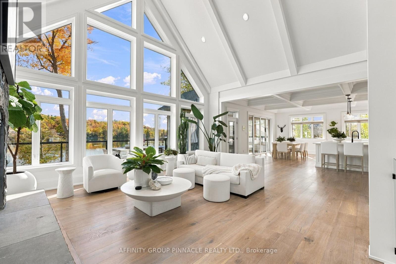 Bright great room with vaulted ceiling, stone fireplace and lake-facing windows
